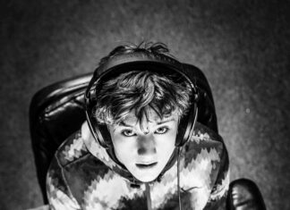 6 Mistakes that new gaming channels make (and how to avoid them) Young gamer looking up at camera while sitting at a desk