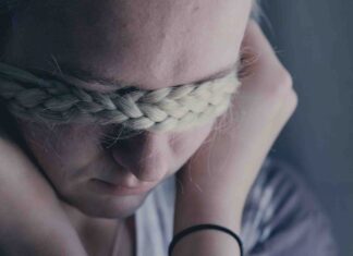 Expressing vulnerability on YouTube Girl pulling braids in front of her eyes as if to hide from the camera