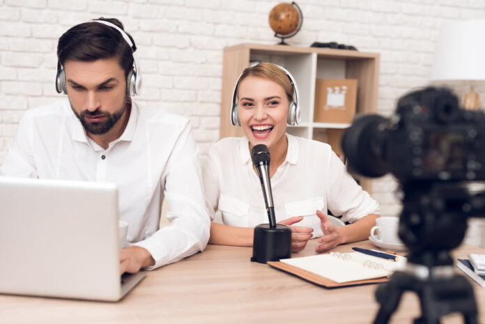 012 Live inset Man at a computer with a woman talking to a camera in the foreground
