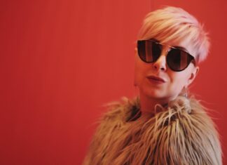 Don’t stress over your subscriber count woman wearing brown fur coat against a red backdrop