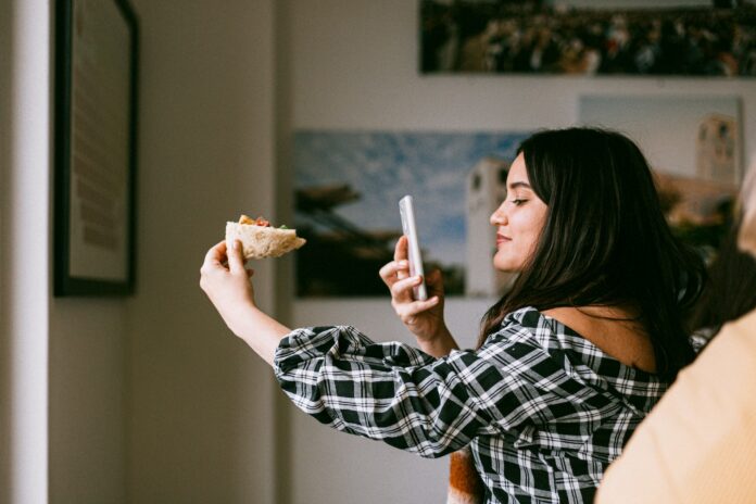 food-pizza-woman-beautiful-3326713 influencer taking a photo of food with a smartphone