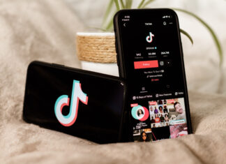 TikTok creators can now put videos behind paywalls TikTok profile and logo on phone.